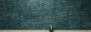 Still from the movie A Serious Man, 2009. Picture of a male professor standing in front a very big blackboard filled with math formulas.
